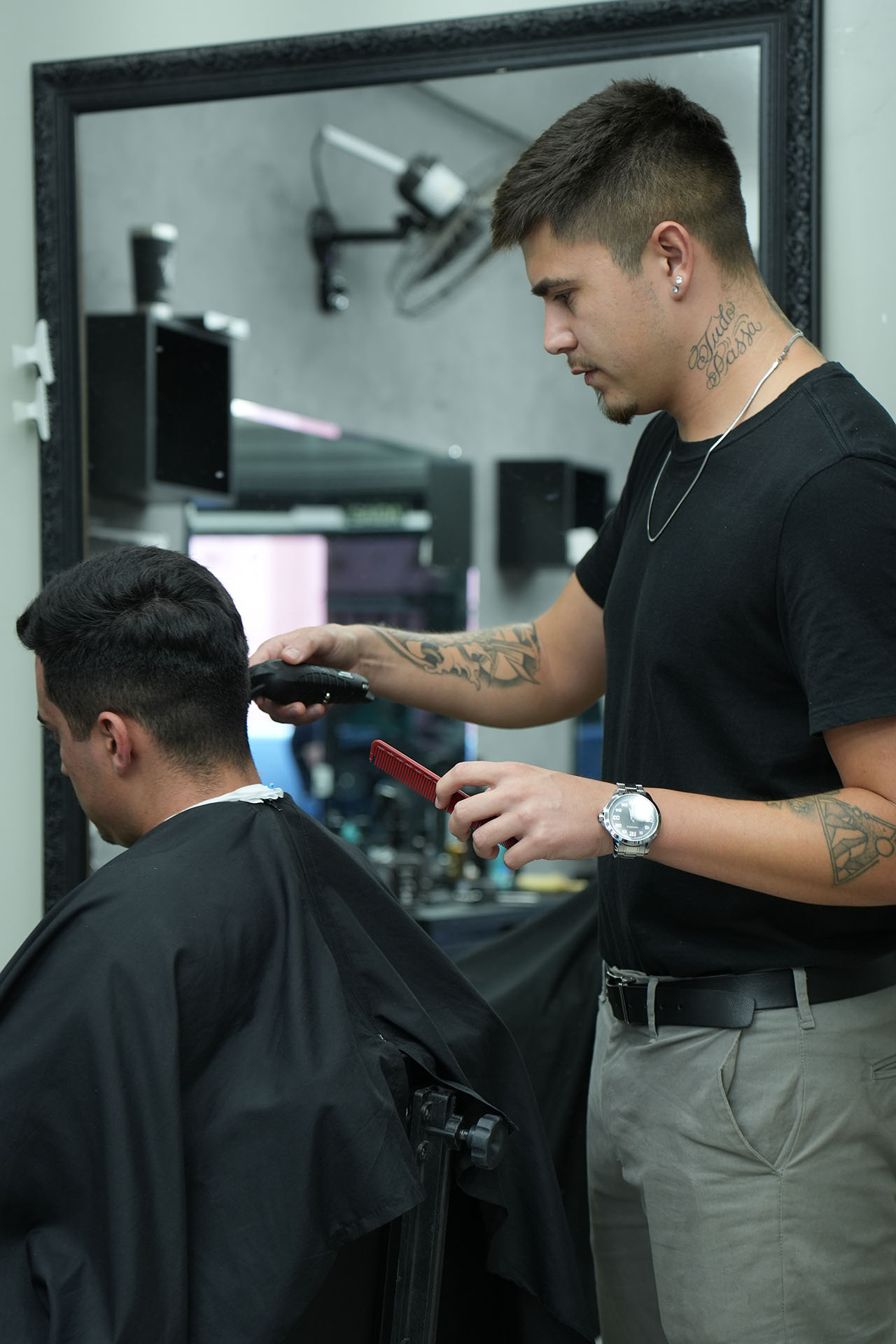 Barbeiro da Barbearia XV realizando um corte